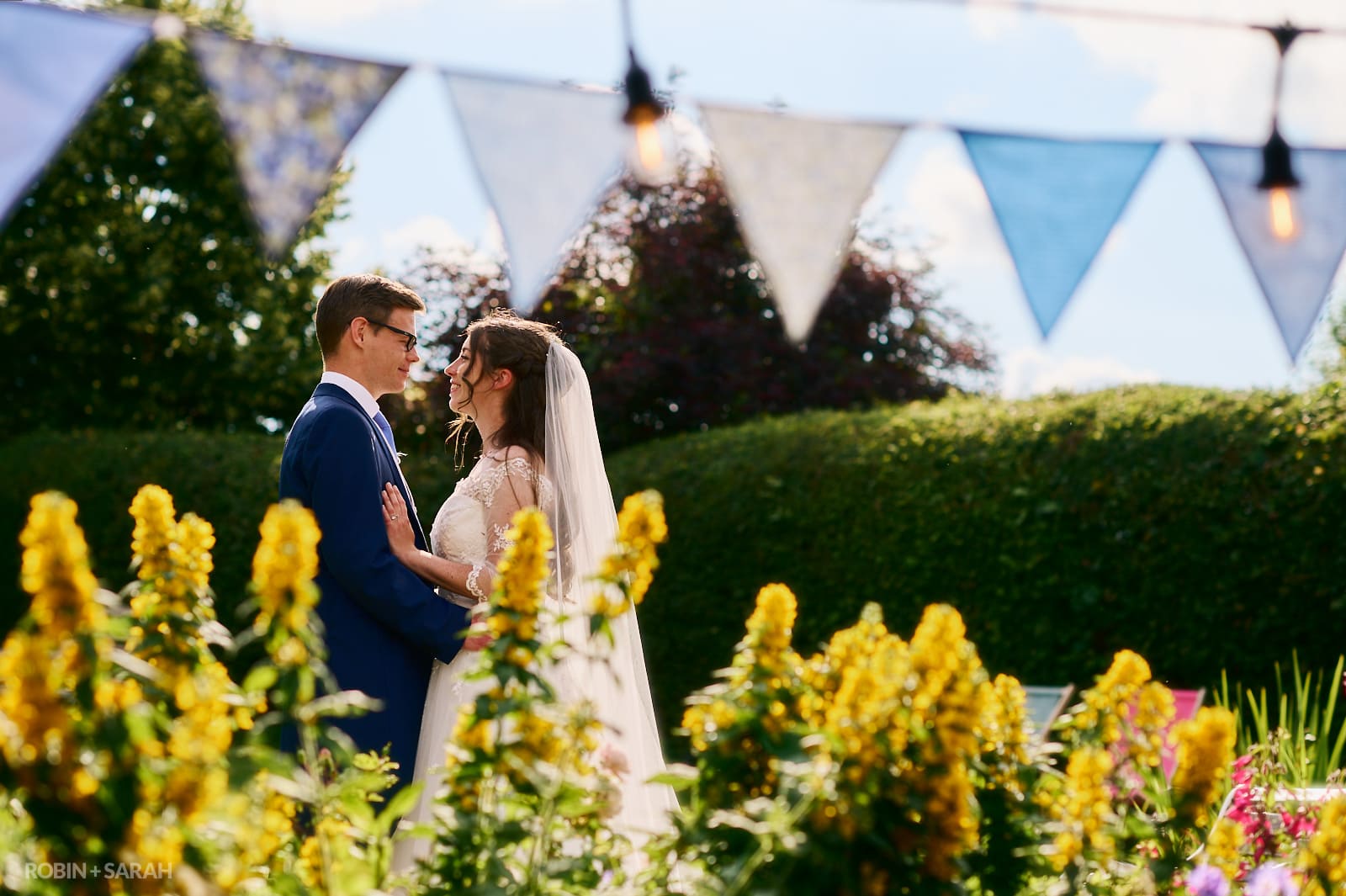 Bride and groom in gardens at Wethele Manor under bunting