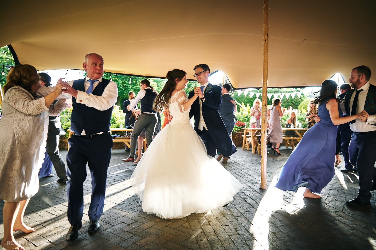 Bride, groom and guests dance to ceilidh