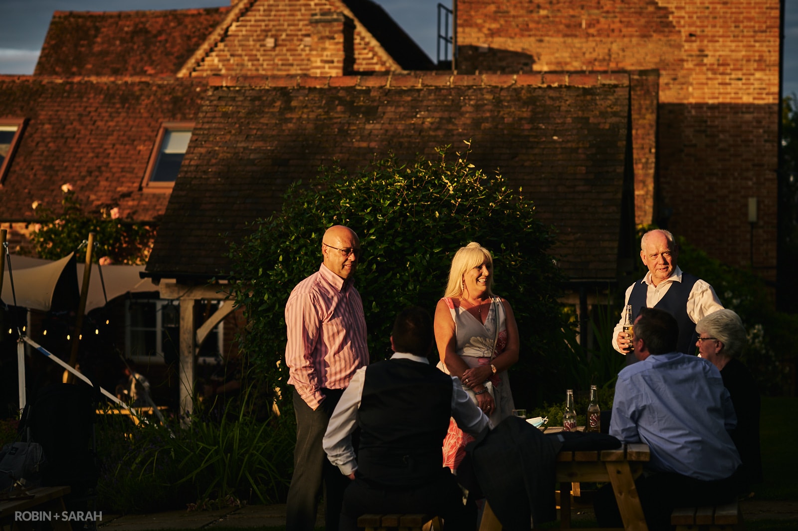 Wedding guests chat in beautiful light at Wethele Manor