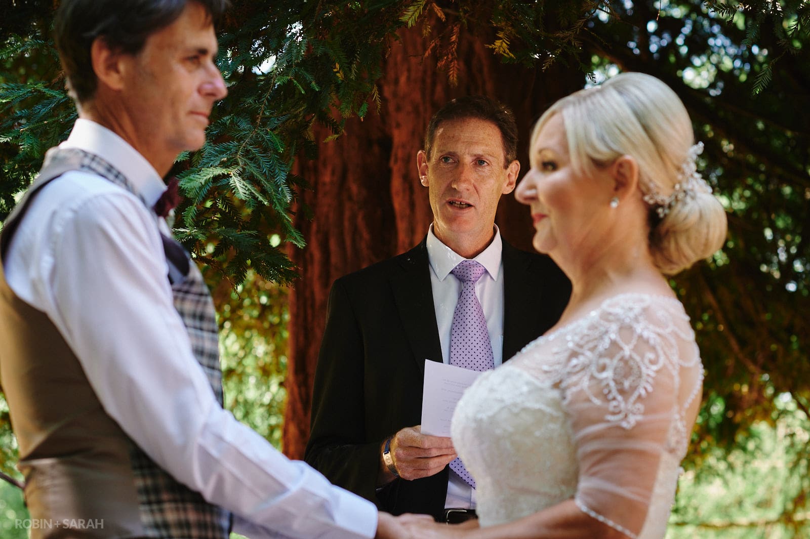 Wedding ceremony held outdoors under tree