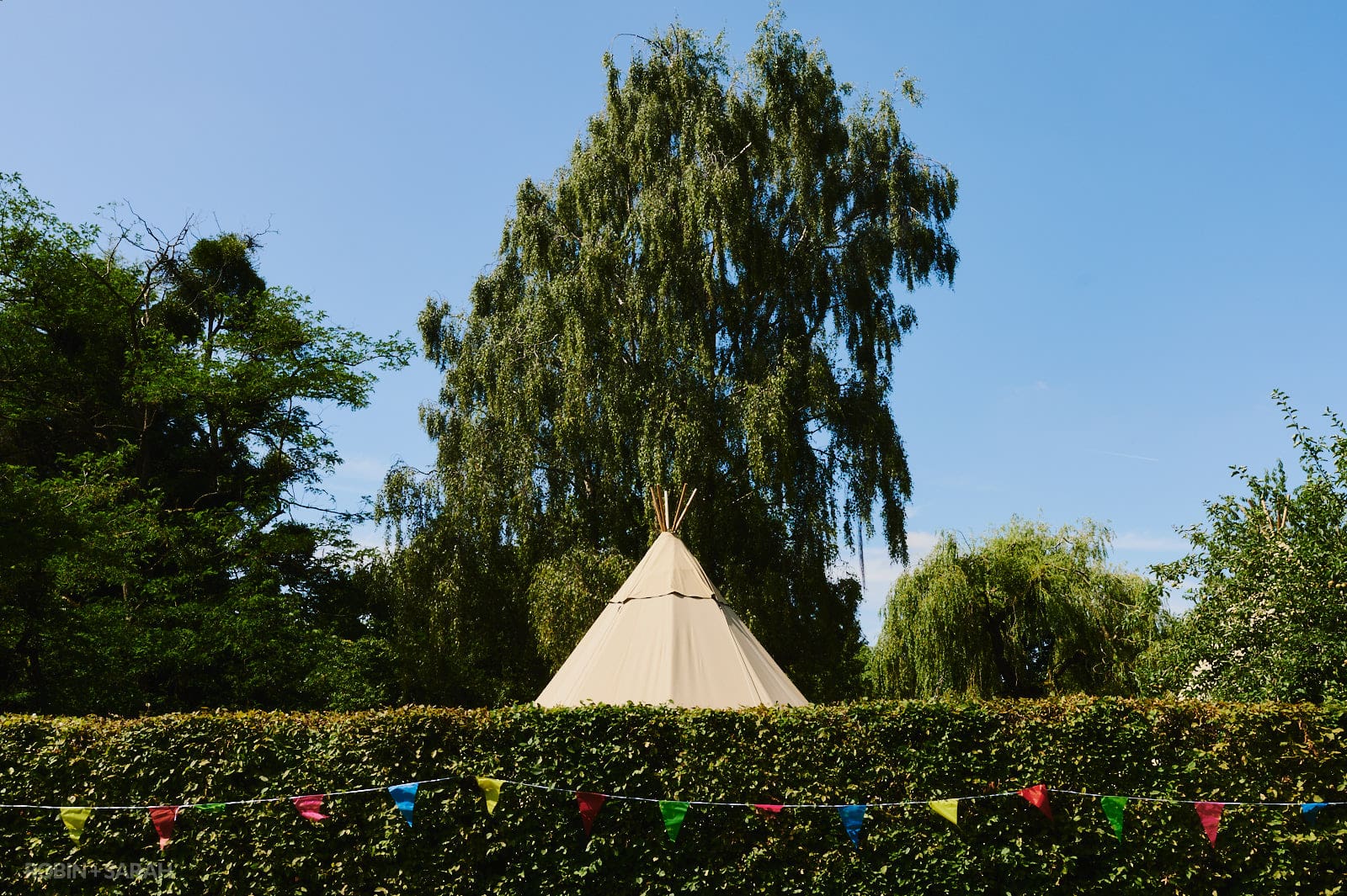 Top of wedding tipi at Oakfield Gardens, with bunting along hedgerow
