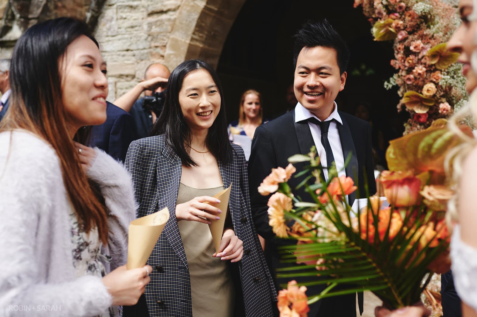 Wedding guests congratulate bride and groom outside church