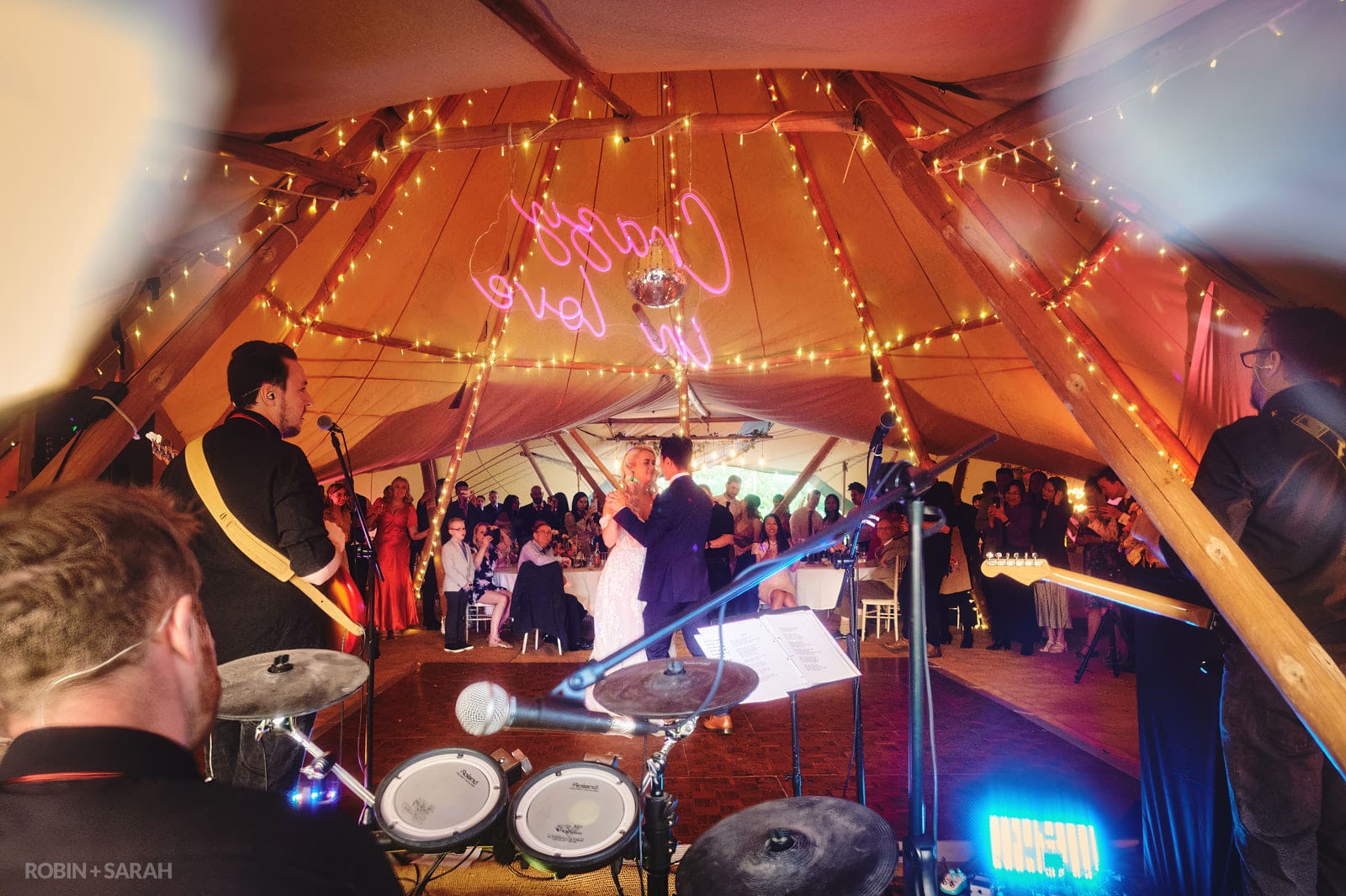 Bride and groom first dance in tipi at Alcott Wedding as live band play