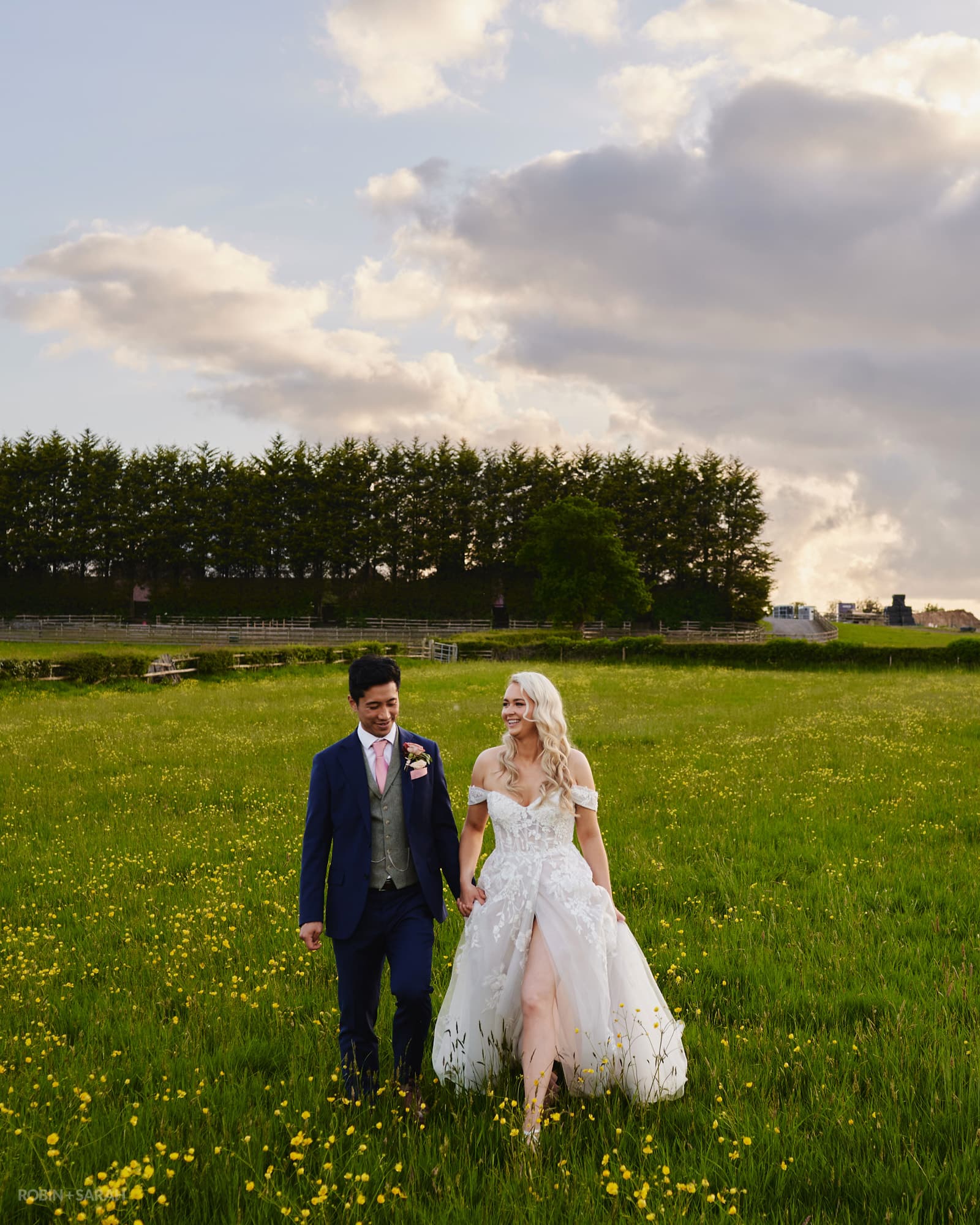 Bride and groom walk through beautiful fields at Alcott Farm