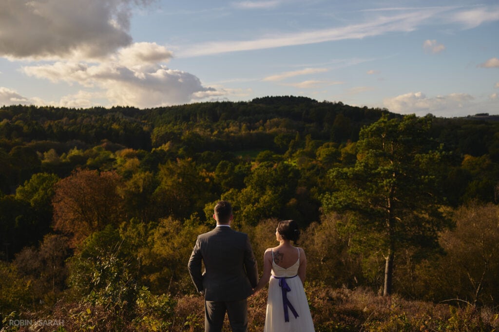 Bride and groom looking out over rolling hills near Bromsgrove