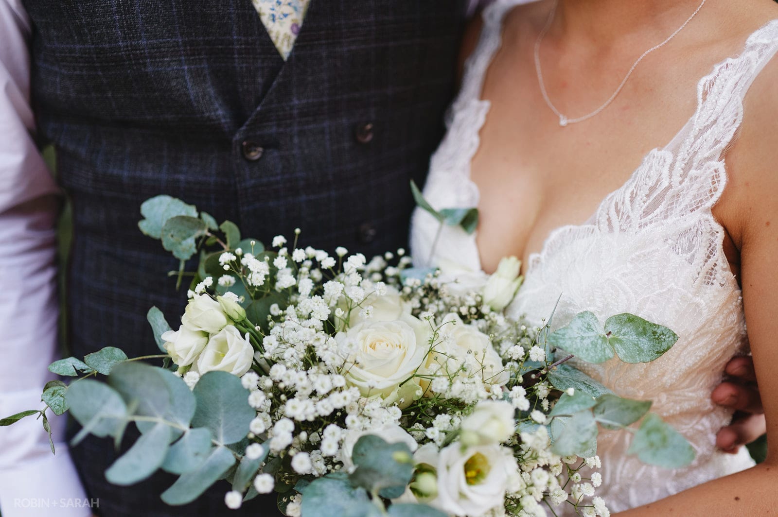 Detail of bridal bouquet and wedding dress