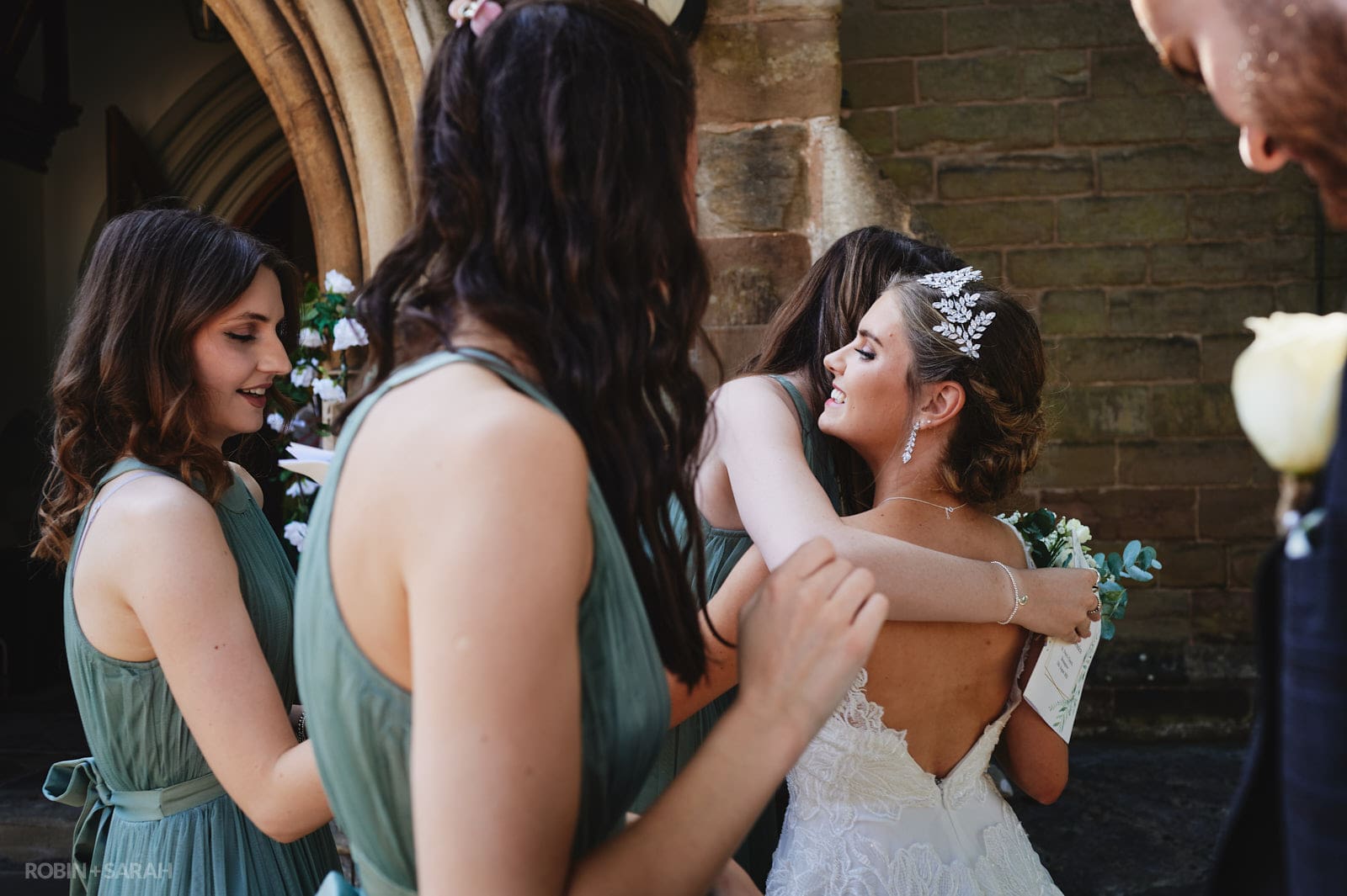 Bride hugs bridesmaids after wedding ceremony