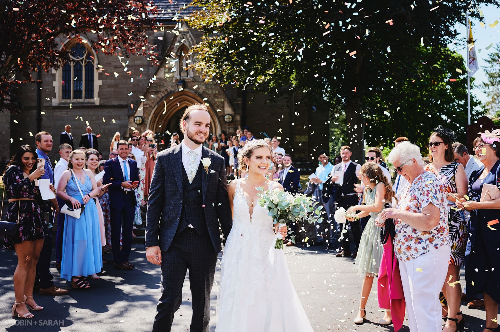 Wedding guests throw confetti over bride and groom at St Peter's Catholic church Bromsgrove