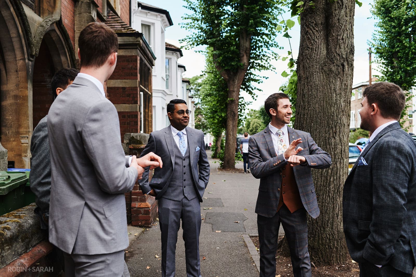 Groom and friends outside church waiting for wedding guests to arrive