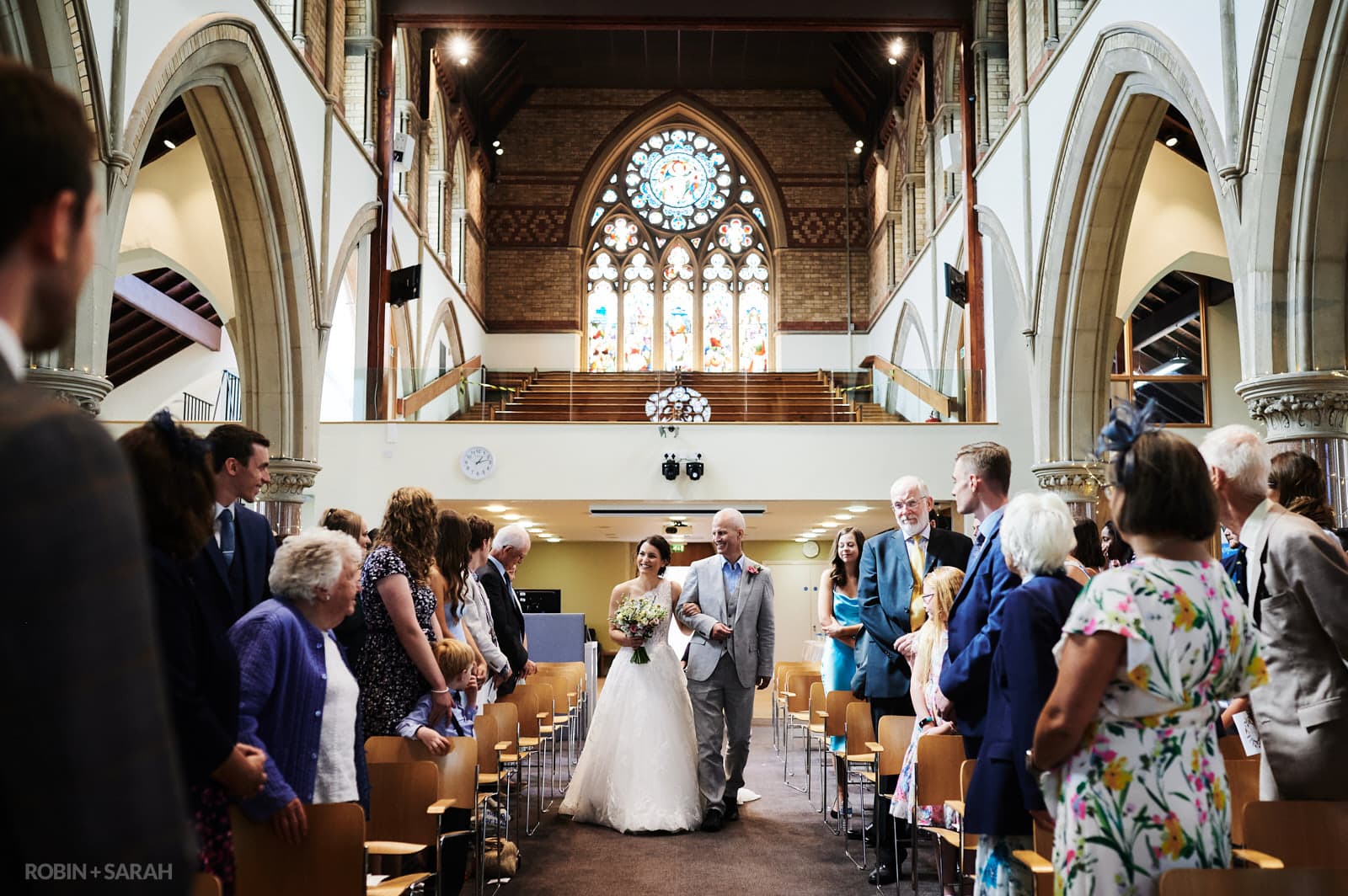 Bride and dad waalk up aisle at St Pauls church in Leamington Spa