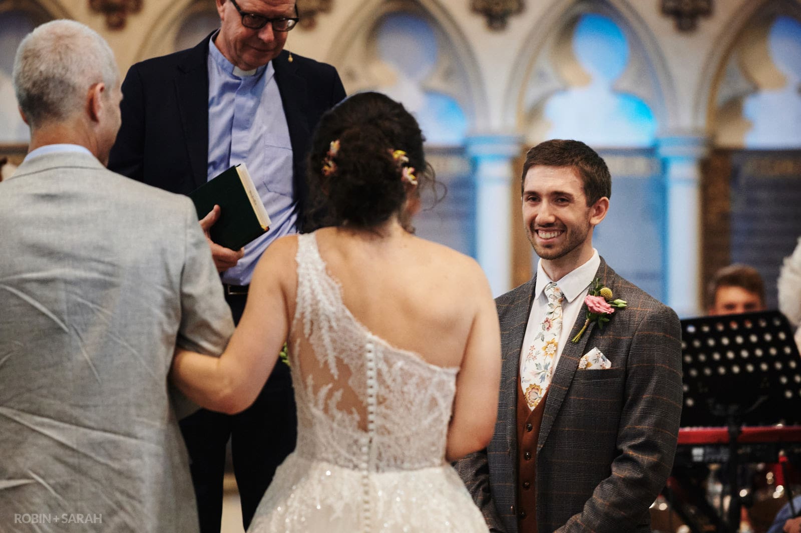 Groom smiles at bride as she walks up aisle