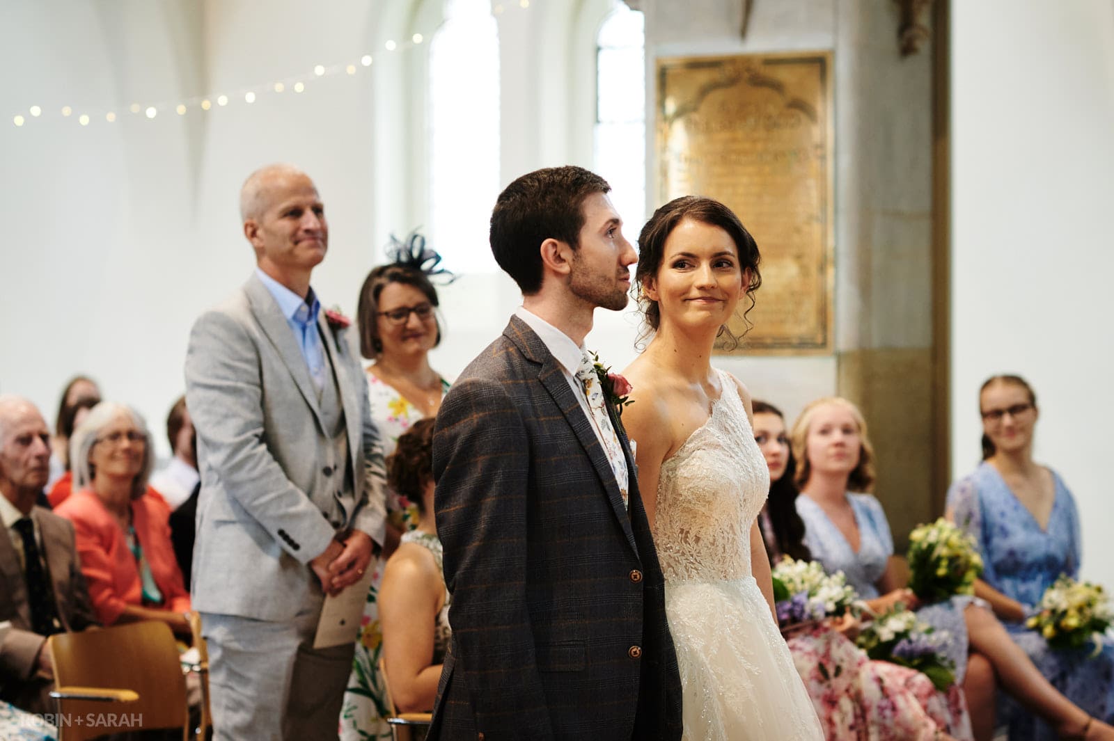Bride smiles at groom during church wedding ceremony