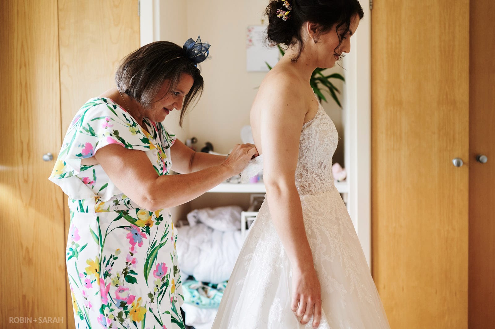 Bride's mum fastens wedding dress