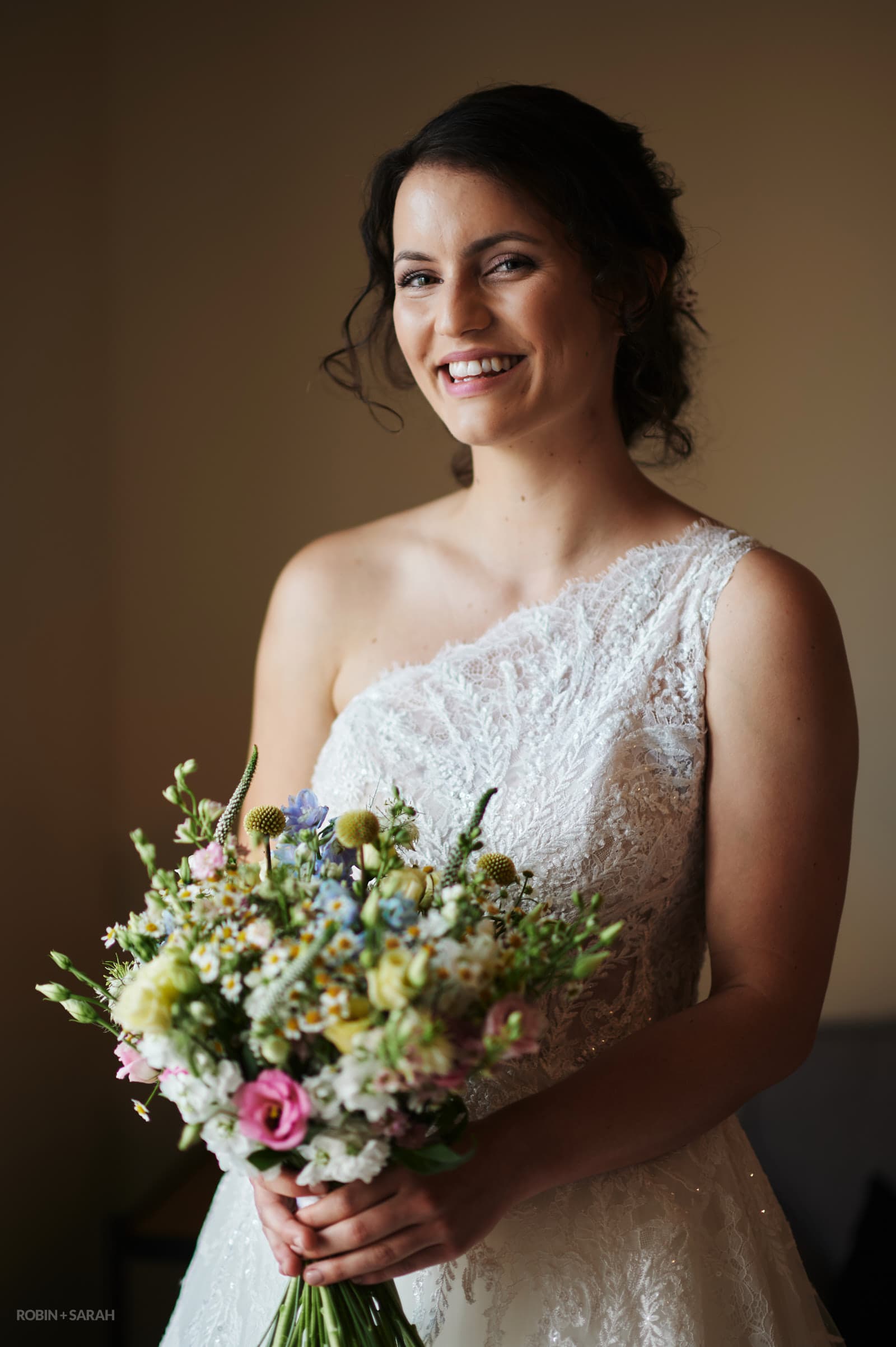 Portrait of beautiful bride holding bouquet of flowers