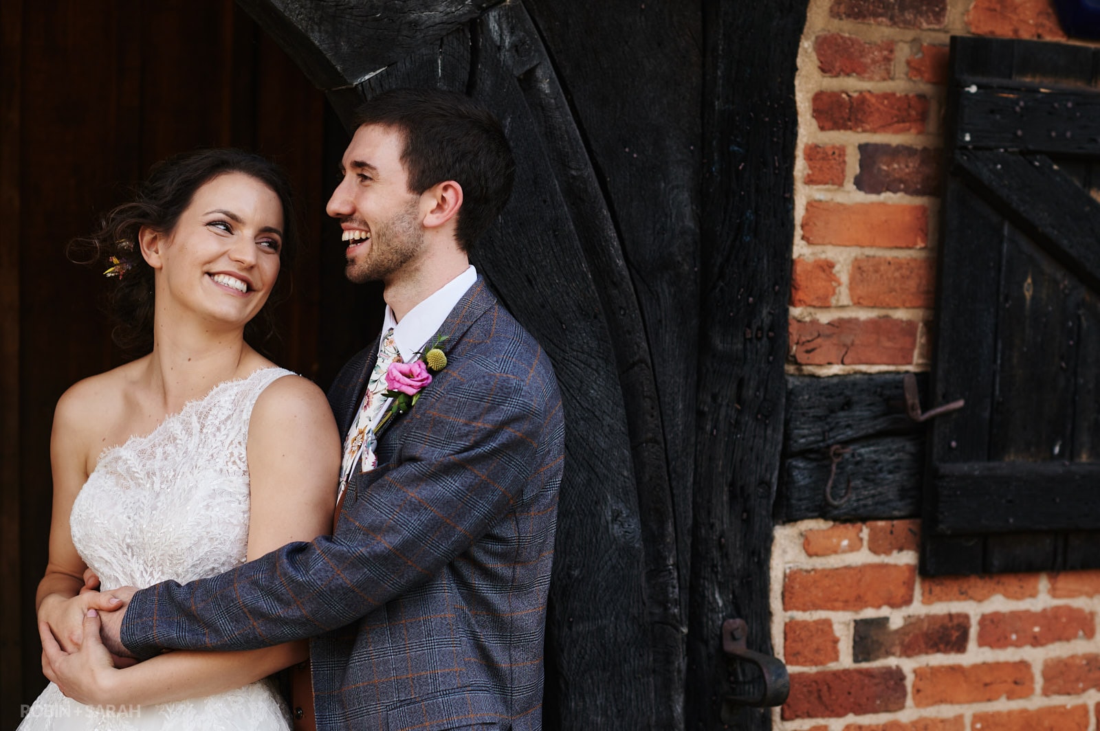 Bride and groom relax together in archway of old building