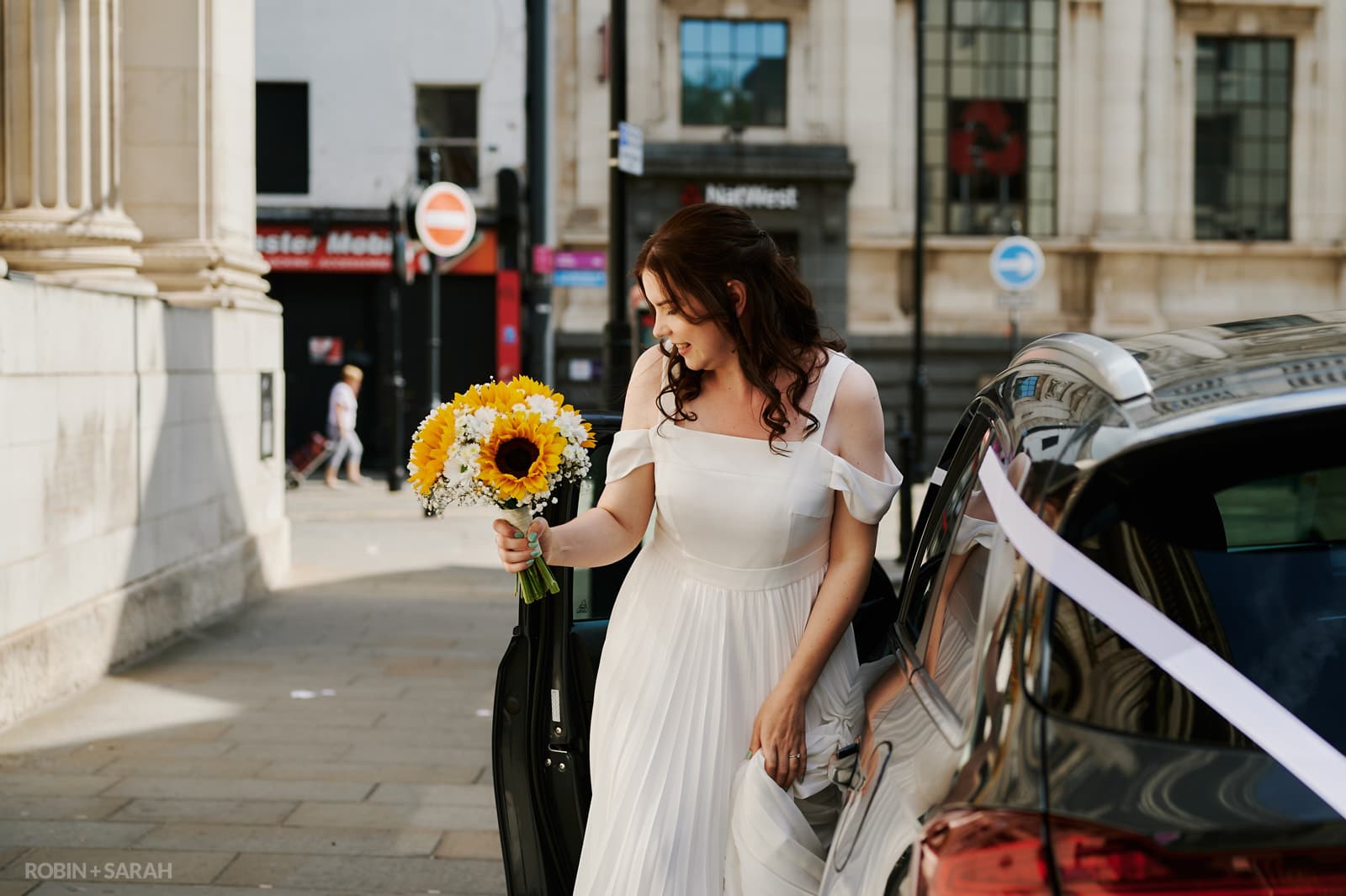 Bride gets out of car for wedding ceremony
