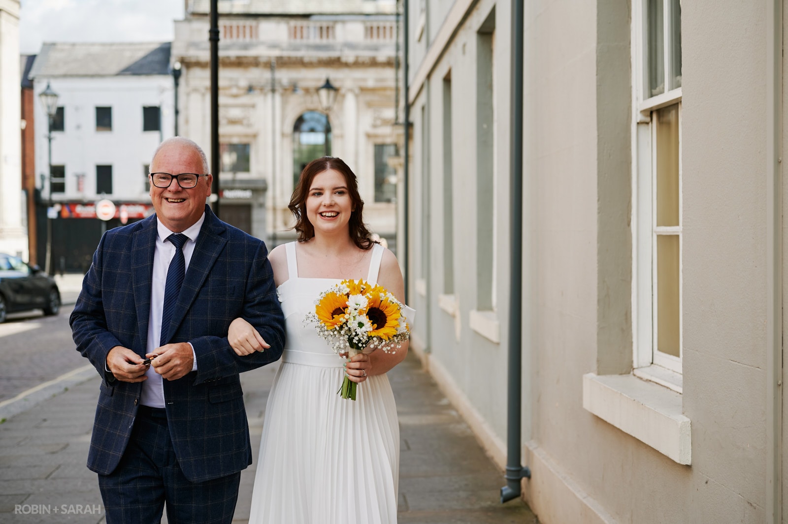 Bride and dad walk into Priory Place for wedding ceremony
