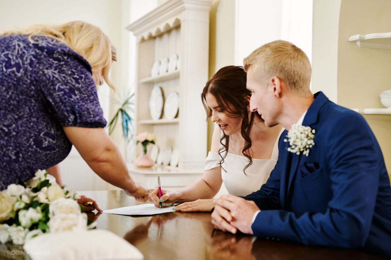 Bride and groom sign marriage register at Prior Place wedding