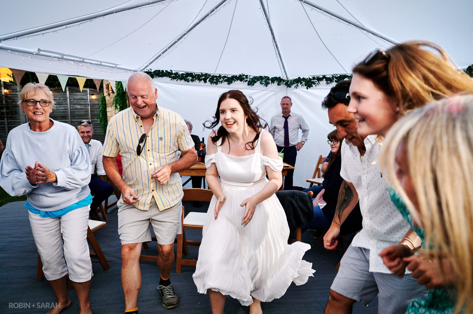 Bride and guests dancing at wedding party held at home