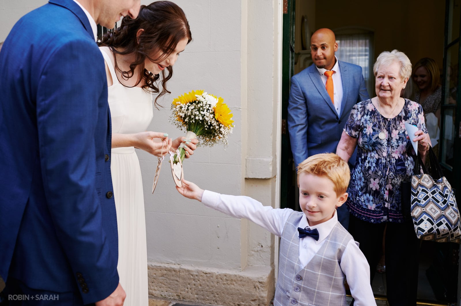 Young boy gives horsehoes to bride and groom after wedding ceremony