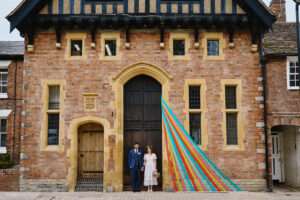 Bride and groom standing in doorway of old brick building