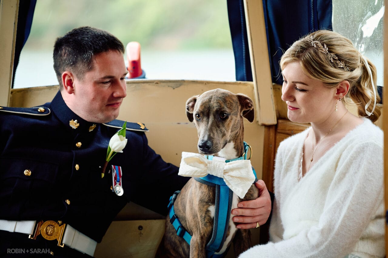 Bride, groom and their dog on a boat