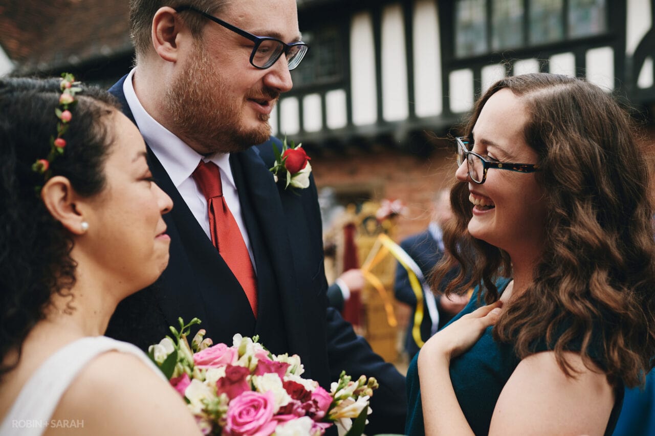 Bride and groom chat with wedding guest after ceremony