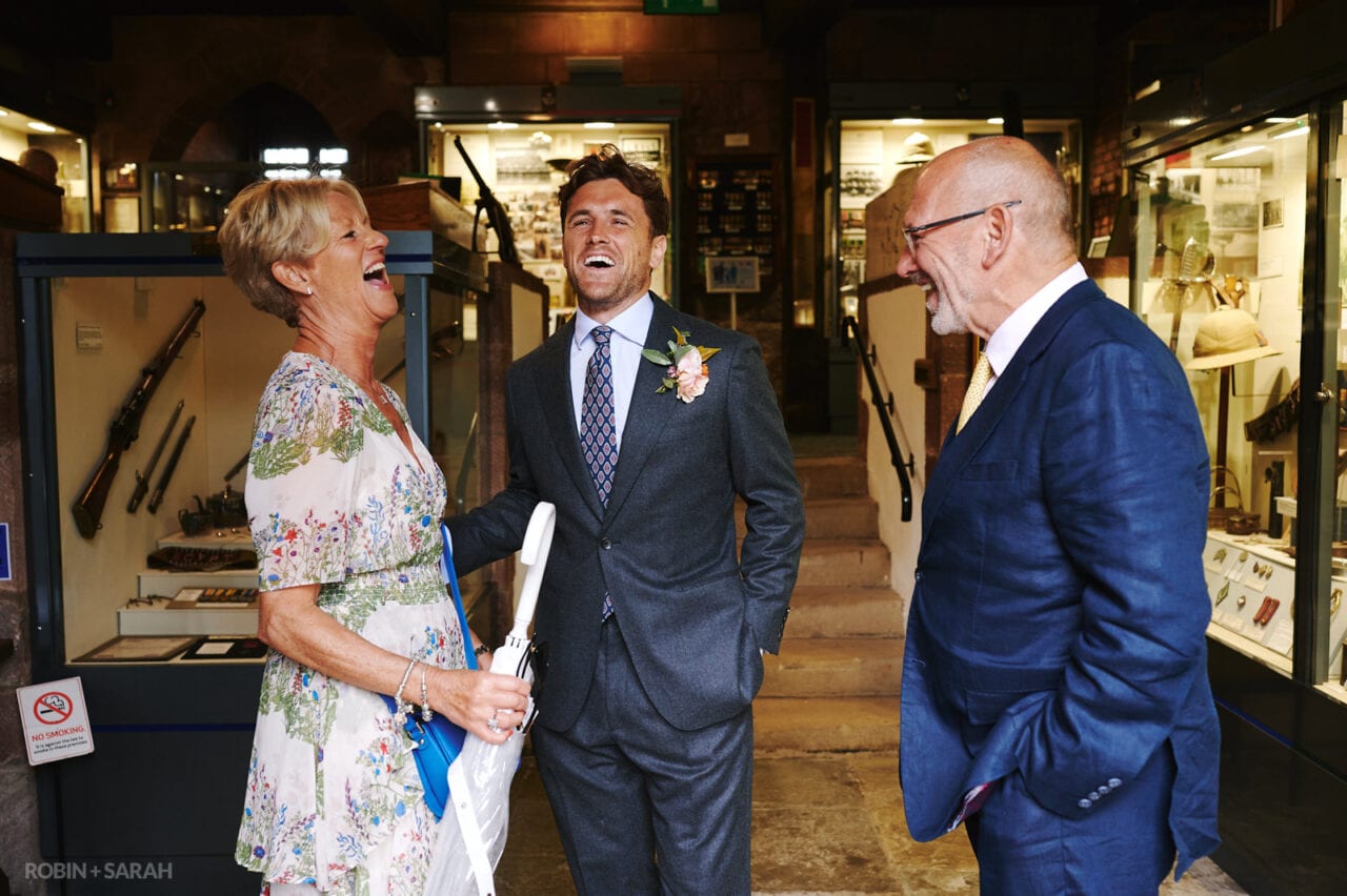 Groom shares a laugh with parents at wedding