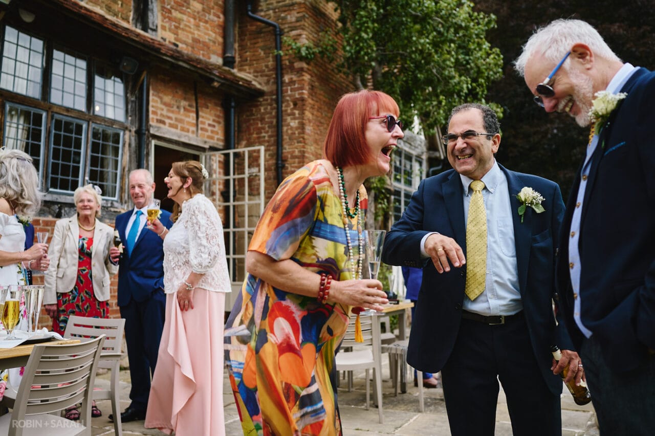 Wedding guests relax and share a laugh at small wedding