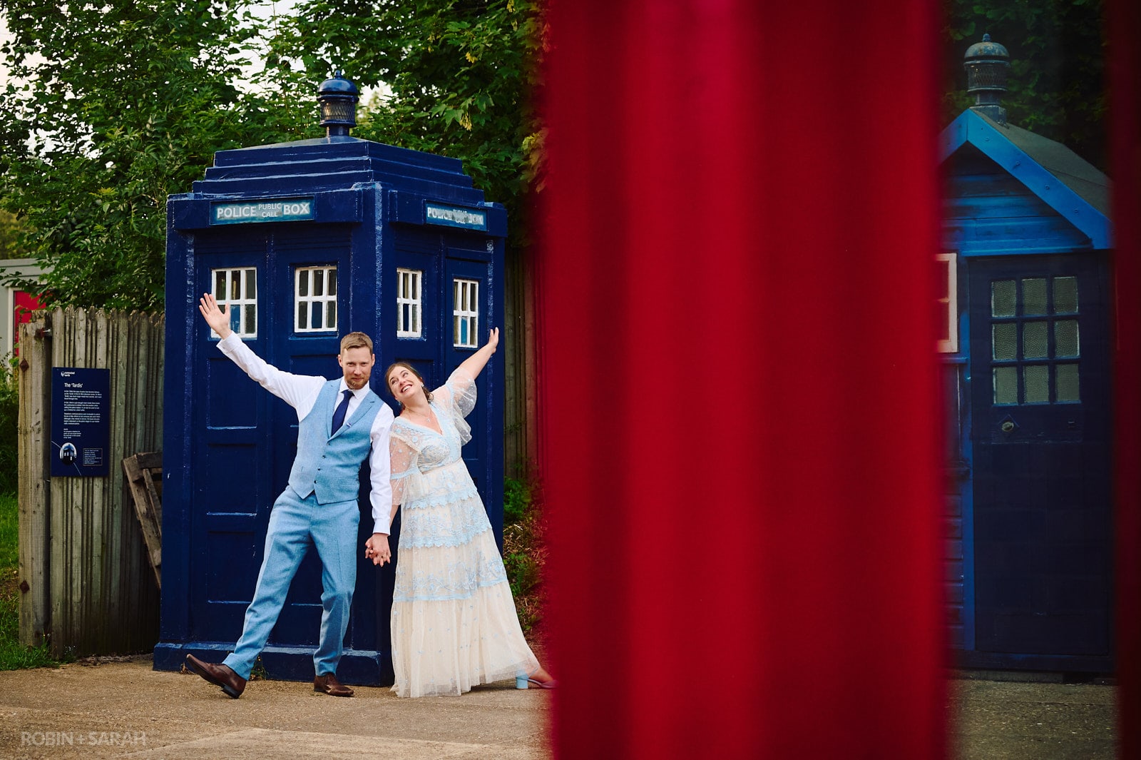 Bride and groom playing about next to Tardis at Avoncroft Museum