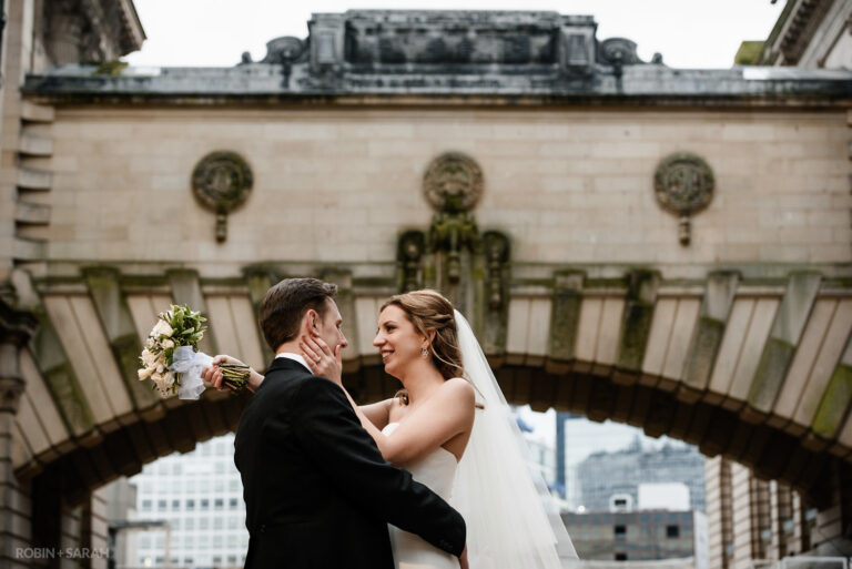 Bride and groom together underneath arched bridge of Birmingham Museum & Art Gallery