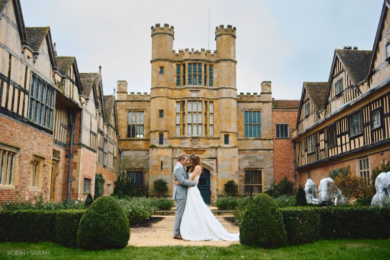 Bride and groom in courtyard at Coughton Court with beautiful architecture