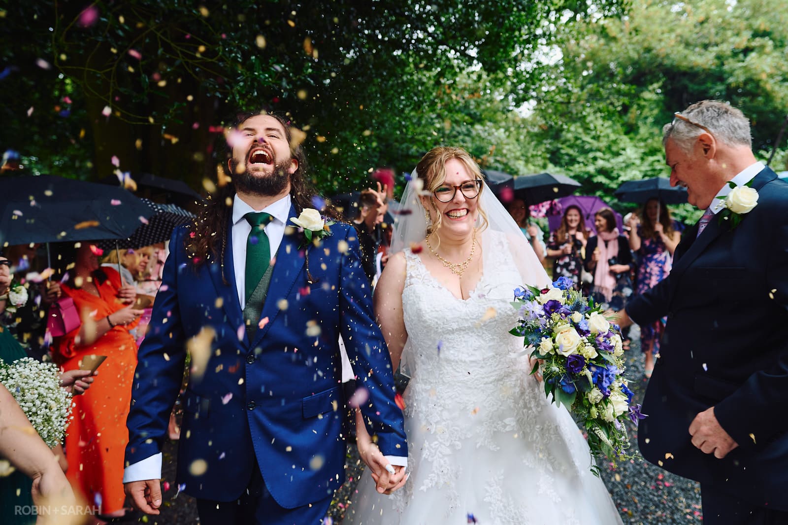 Bride and groom have confetti thrown over them