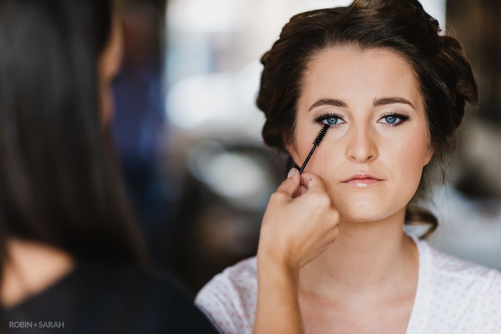 Bride has mascara applied by makeup artist