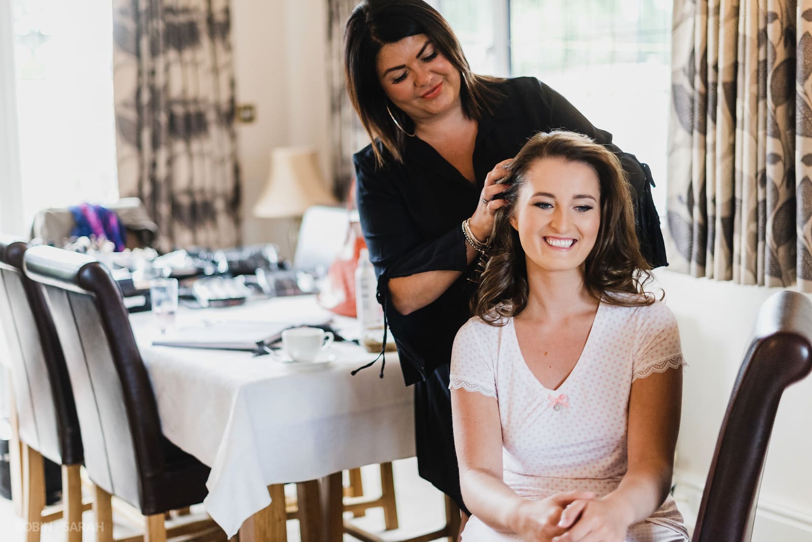Bride has hair styled as she prepares for wedding