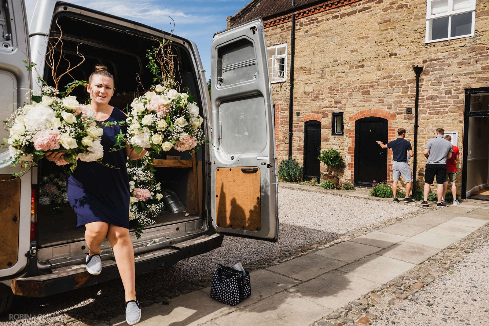 Wedding florist arrives and unloads flowers from her van
