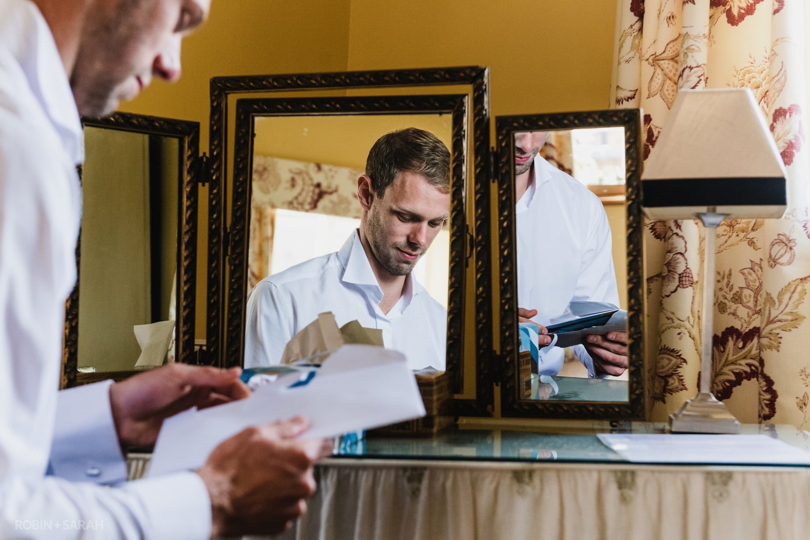 Groom reads card from bride on morning of wedding