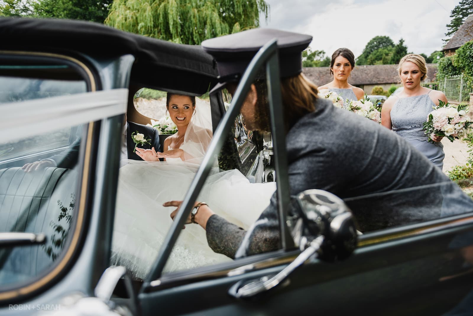 Wedding car drive helps bride out of car as they arrive at church