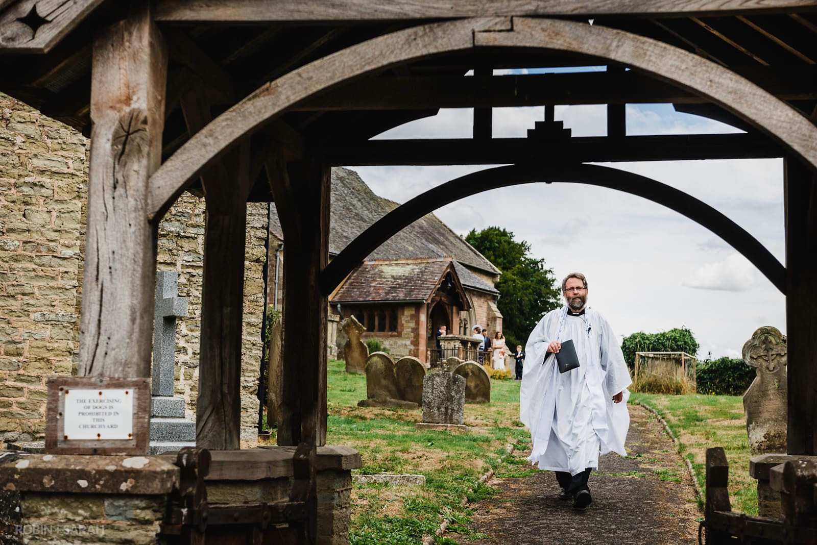 Vicar walks along church path to greet bride