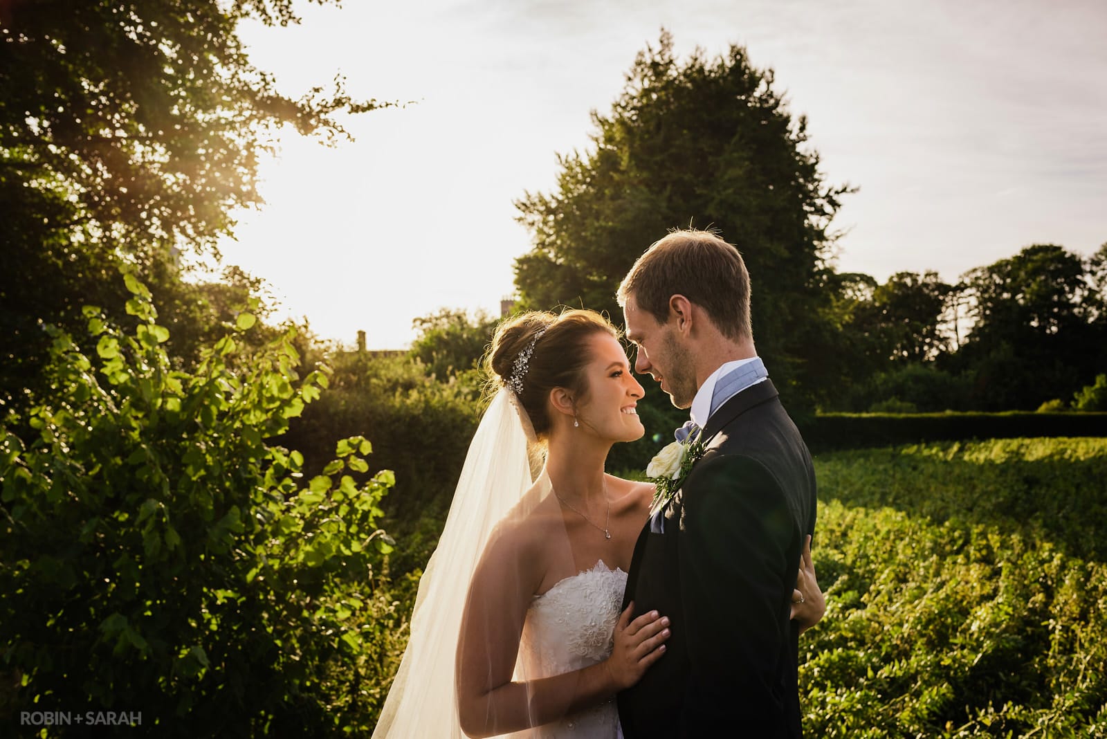 Bride and groom enjoying some time together in beautiful gardens on a summer evening
