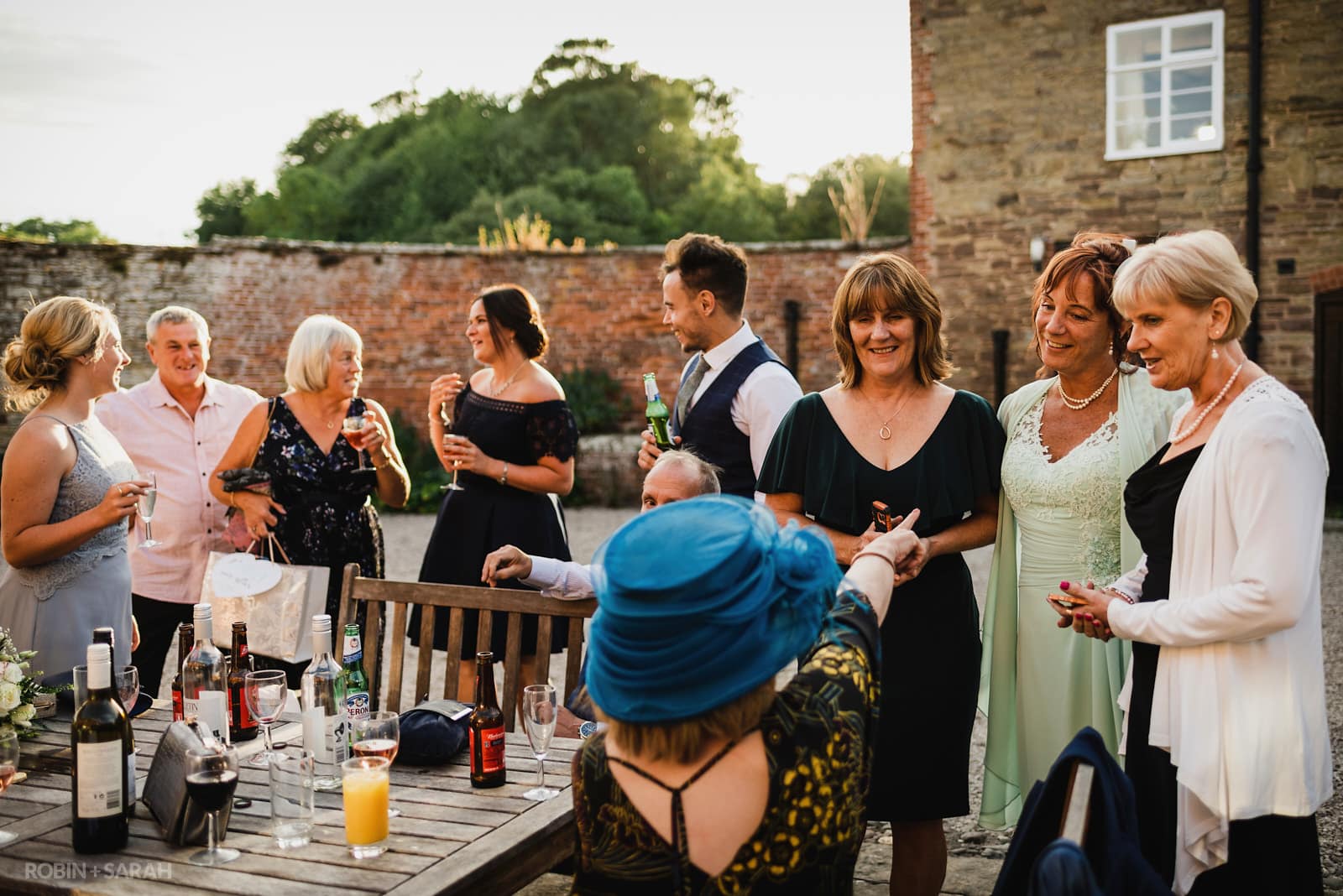 Wedding guests relaxing in the evening sunlight at Delbury Hall