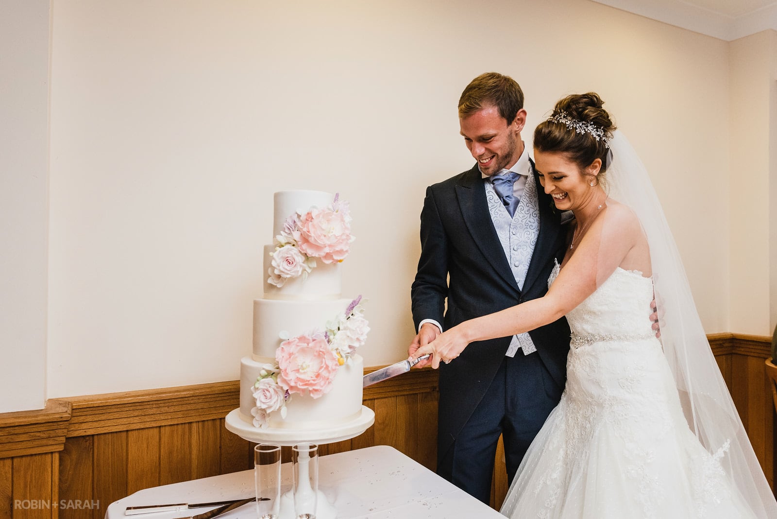 Bride and groom cut wedding cake at Delbury Hall