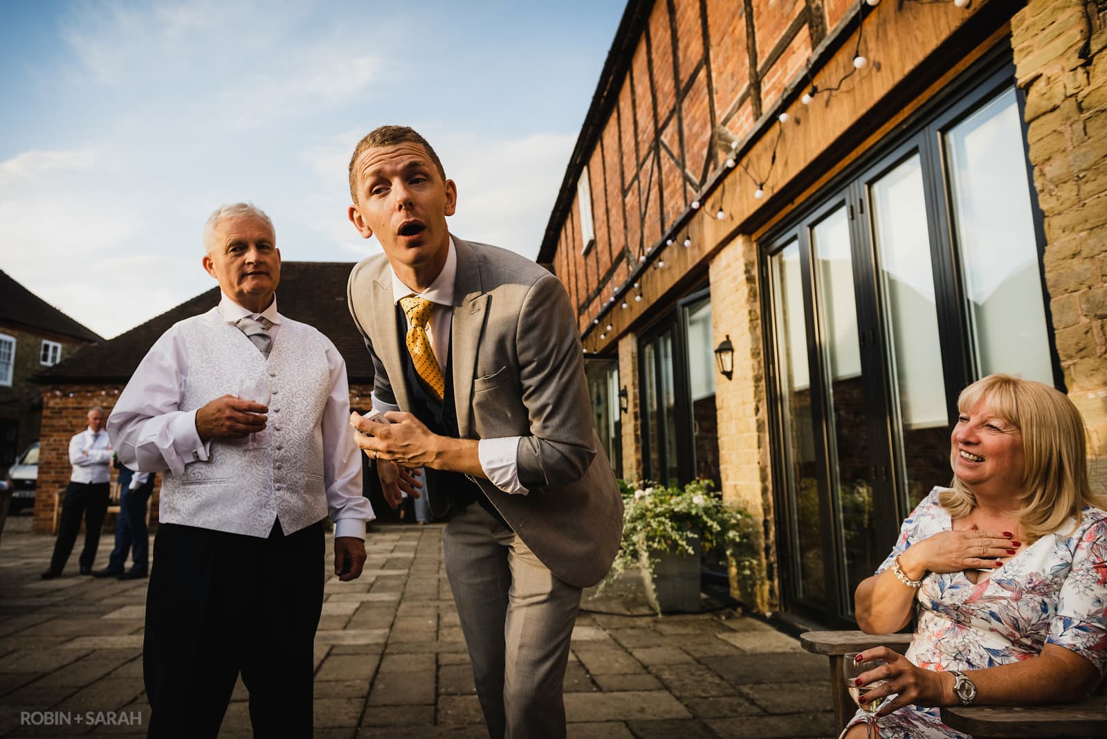 Bride, groom and wedding guests entertained by magician