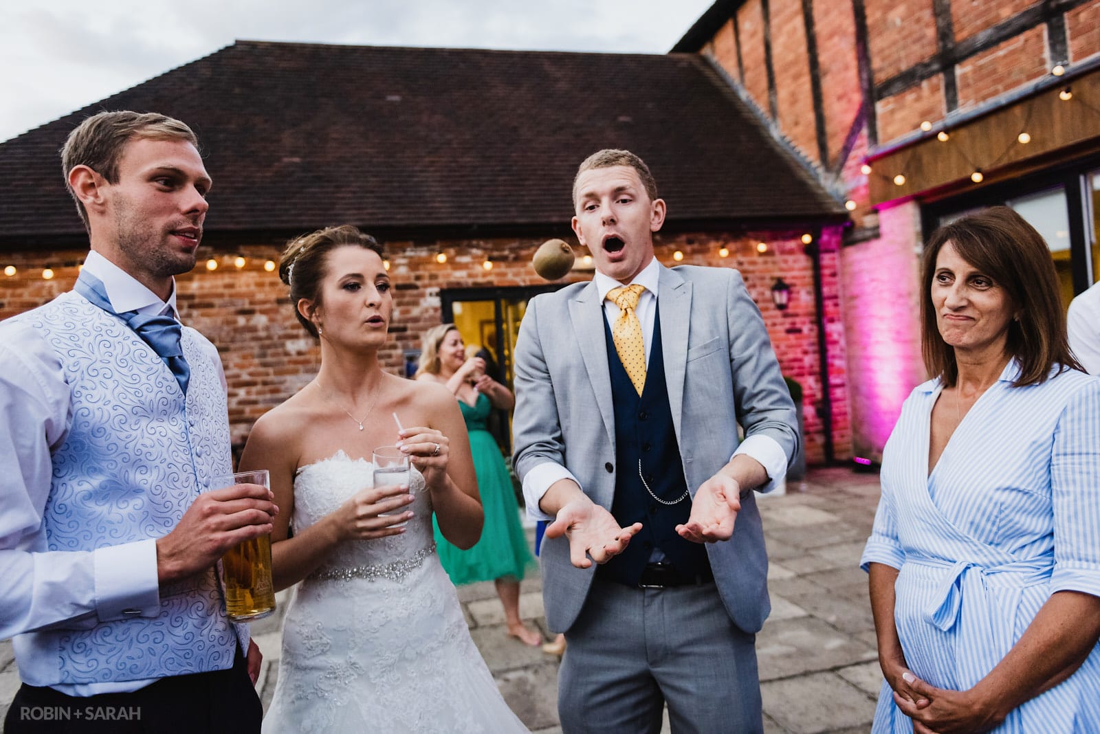 Bride, groom and wedding guests entertained by magician