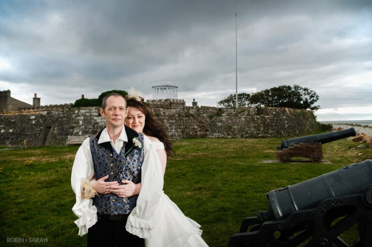 Bride and groom at Fort Belan, standing next to cannons