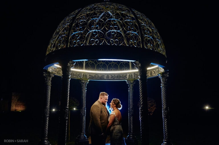 Newly married couple under beautiful metal dome at Foxtail Barns, at night.