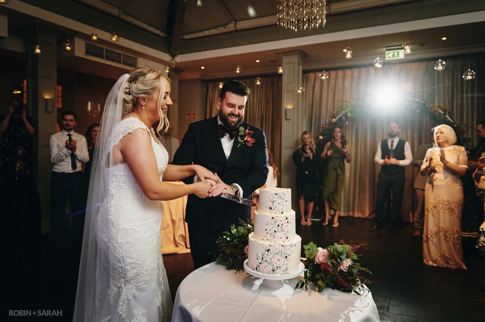 Bride and groom cut cake at Hampton Manor wedding