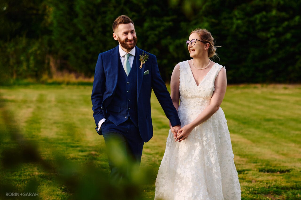 Bride and groom walk in gardens at Pendrell Hall