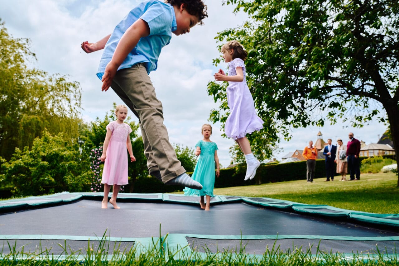 Kids playing on trampoline at small wedding