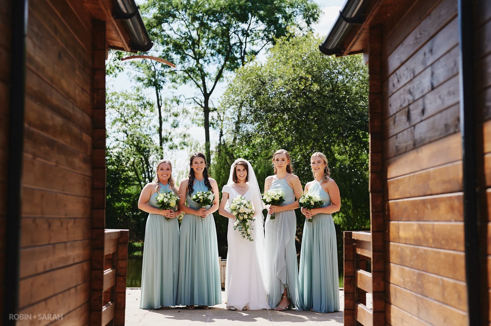 Wedding group photo between chalets at Wethele Manor, or bride and bridesmaids